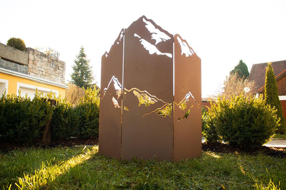 Trennwand Gartendeko aus Edelrost mit einem ansprechenden Bergmotiv, dient als stilvolle und praktische Raumtrennung im Außenbereich.