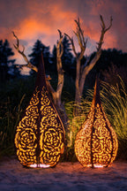 „Stimmungsvolle Beleuchtung eines Edelrost-Windlichts im Garten bei Dämmerung“