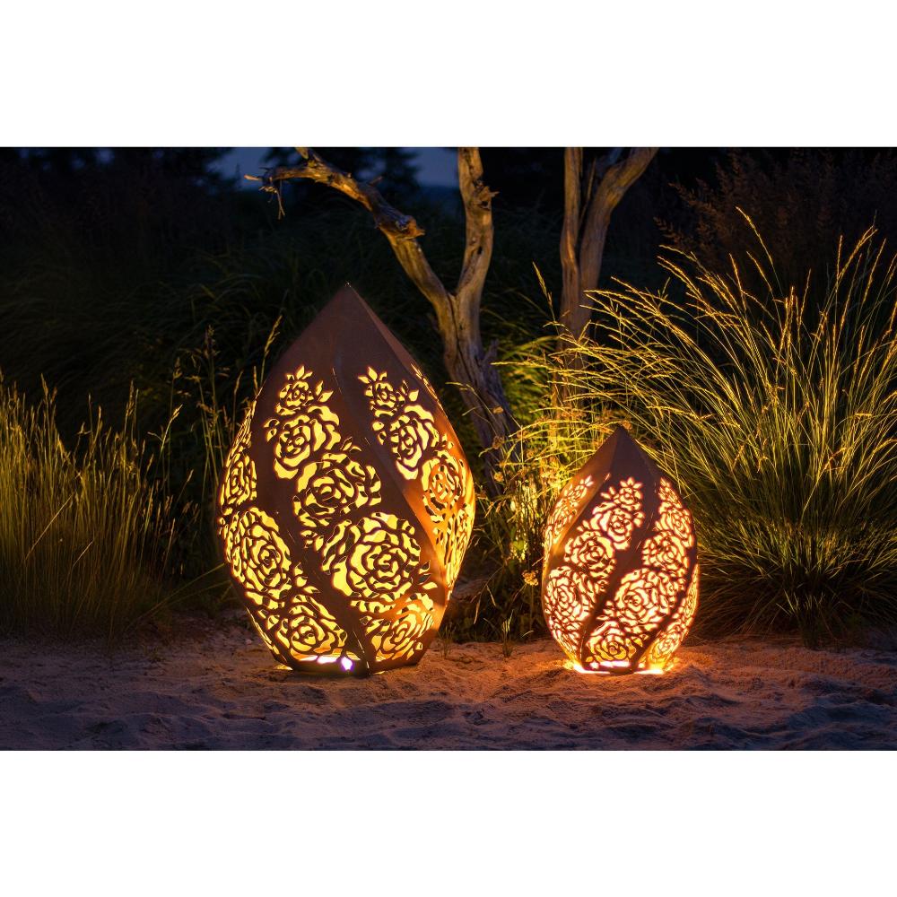 „Zwei Windlichter Rosentraum Edelrost in verschiedenen Größen, dekorativ im Garten arrangiert für stimmungsvolle Beleuchtung“